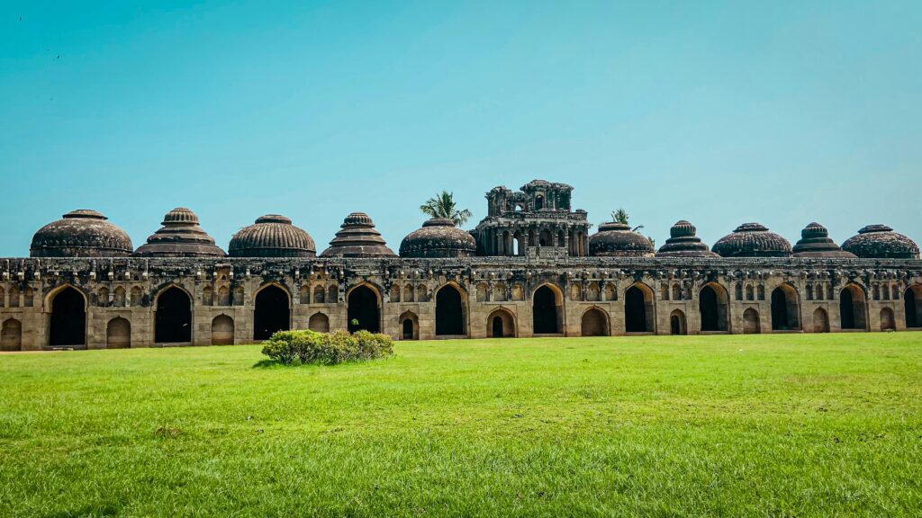Majestic Elephant Stables in Hampi, India, showcasing stunning architecture and lush surroundings.